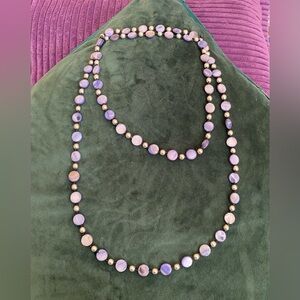 Blue and black iridescent beads with silver separators on black silk rope.